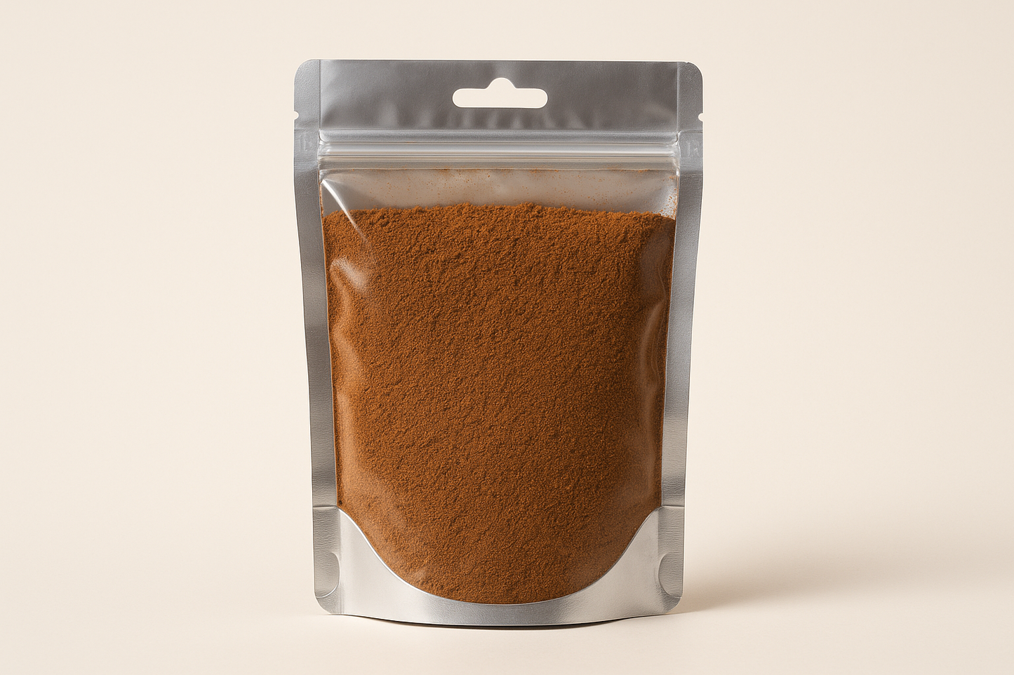 A highly realistic, front-facing product photo of a 100g hanging pouch made of aluminum with a fully transparent front from top to bottom, clearly showing the contents inside. The contents should be clove powder, packed naturally with realistic textures and lighting. The aluminum is only visible on the sides and a small portion at the bottom. The image should have soft, natural shadows and plain background (hex #faf6f1). No text, labels, or branding just the pouch and its contents.