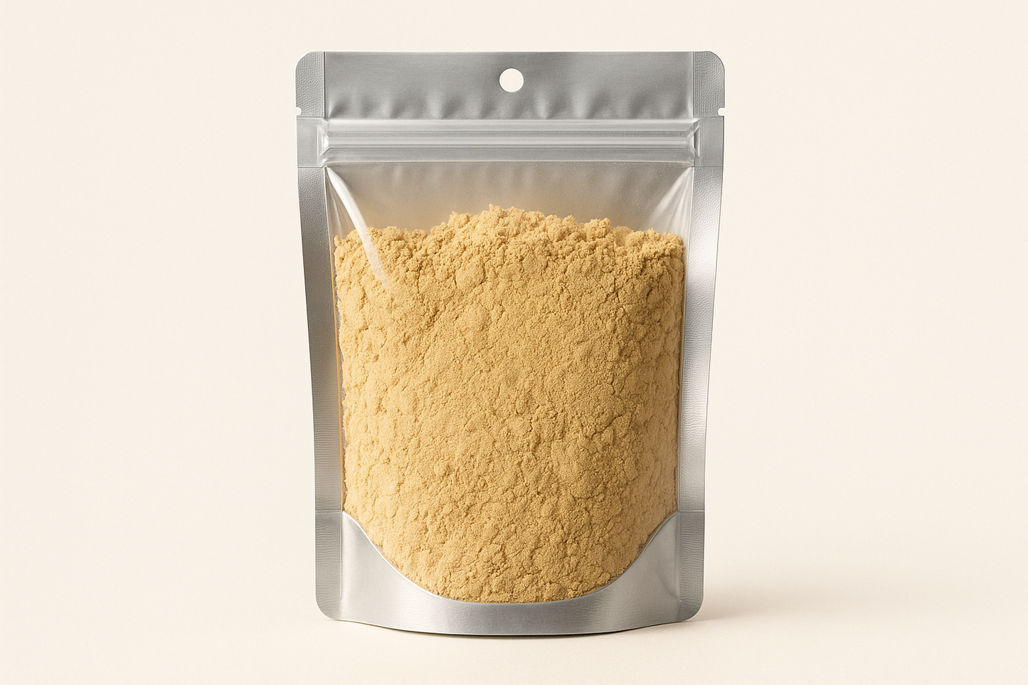 A highly realistic, front-facing product photo of a 100g hanging pouch made of aluminum with a fully transparent front from top to bottom, clearly showing the contents inside. The contents should be ginger powder, packed naturally with realistic textures and lighting. The aluminum is only visible on the sides and a small portion at the bottom. The image should have soft, natural shadows and plain background (hex #faf6f1). No text, labels, or branding just the pouch and its contents.